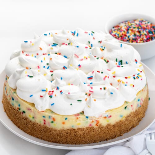 生日芝士蛋糕在白色板白色柜台用叉子,一条毛巾,洒在后台。