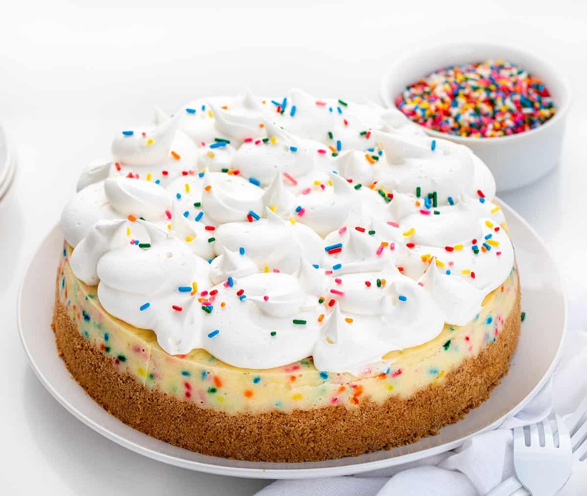 生日芝士蛋糕在白色板白色柜台用叉子,一条毛巾,洒在后台。