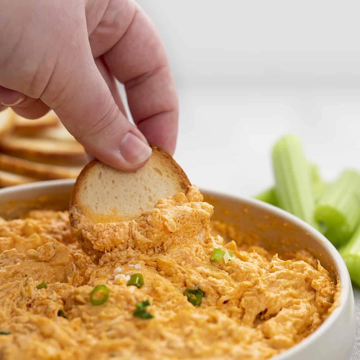 Crockpot Buffalo Chicken Dip is an appetizer made with chicken, cream cheese, cheddar cheese, sour cream, and homemade buffalo sauce. Appetizer, Buffalo Chicken Dip, Slow Cooker Buffalo Chicken, Crockpot Buffalo Chicken, Dips, Superbowl Recipes, Game Day Recipes, Hot Appetizers, Buffalo Chicken Recipes, i am baker, iambaker 手舀水牛城鸡肉蘸百吉饼片