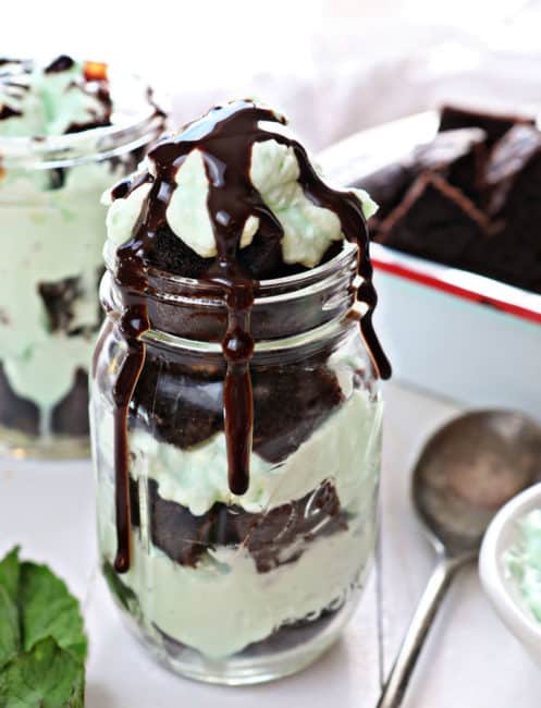 Layered with chocolate cake and peppermint whipped cream, Mason Jar Peppermint Chocolate Treats look as good as they taste! #chocolatepeppermintmasonjartreats #masonjartreats #chocolatepeppermint #chocolatecake #peppermintwhippedcream #desserts #holiday #mint #iambaker 梅森罐薄荷巧克力点心淋上巧克力