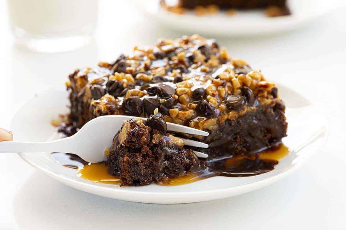 Deliciously moist sheet cake, cooked to perfection, and topped with an ooey-gooey blend of melted caramel, toffee bits, chocolate chips, and sea salt. Chocolate Cake, Baking, Chocolate Sheet Cake, Chocolate Cake Recipe, Salted Caramel Chocolate Sheet Cake, Salted Caramel Cake, Chocolate, Recipes, Desserts, Chocolate Dessert, i am baker, iambaker 咸味焦糖巧克力蛋糕切成白色盘子