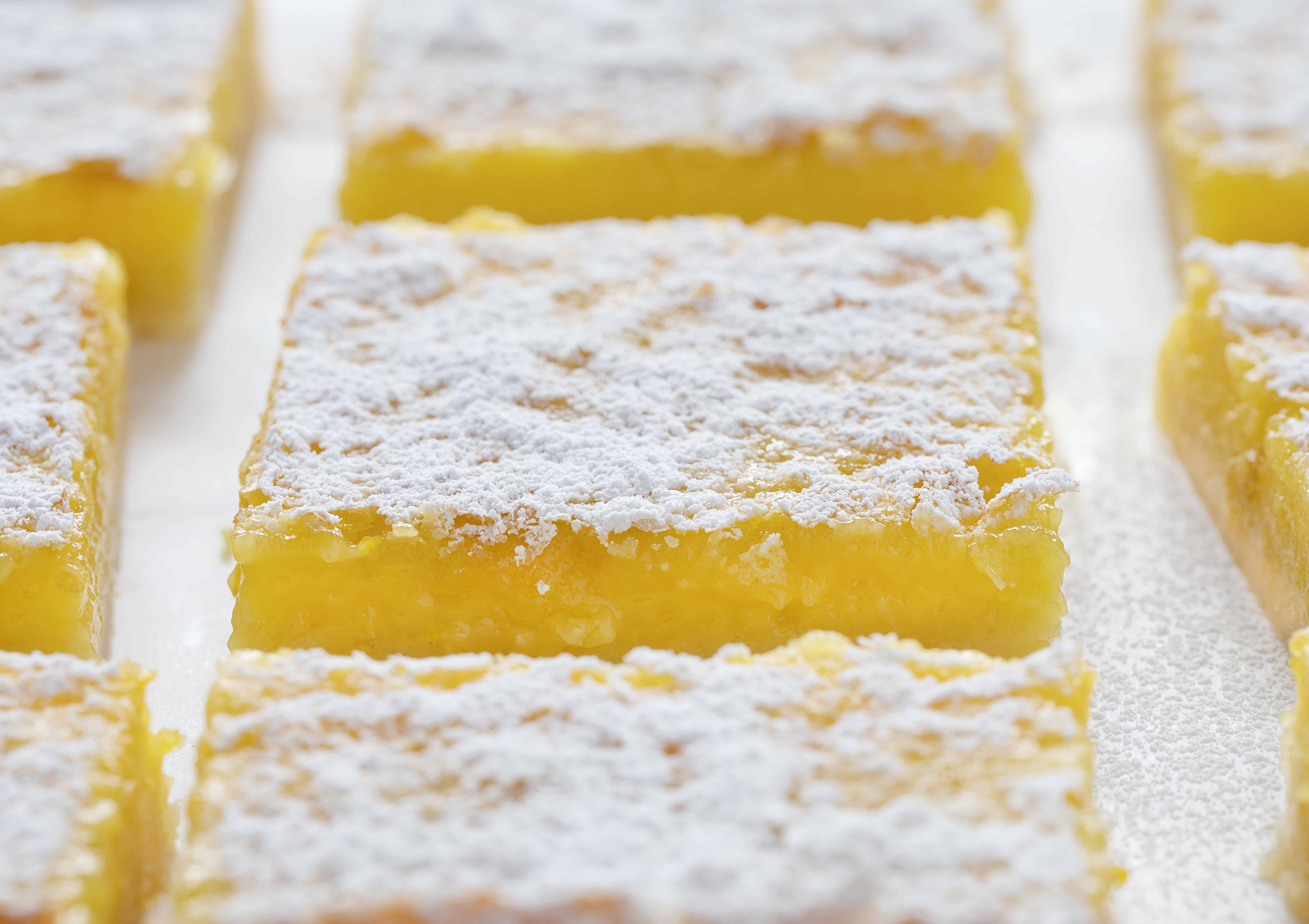 Packed with flavor and seriously sweet, these Orange bars are the perfect summertime treat! #orangebars #bars #summerdesserts #desserts #bbqdesserts #iambaker #recipes 橙色酒吧配方在白色柜台顶部和两侧。gydF4y2Ba