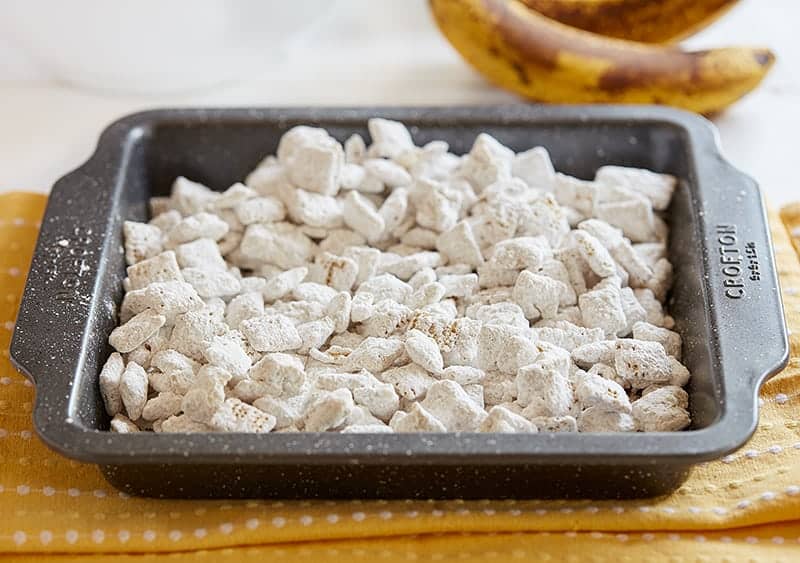 Banana Pudding Puppy Chow--a banana flavored twist to the classic puppy chow (muddy buddies) recipe #bananapuddingpuppychow #muddybuddies #bananapuddingmix #chexcereal #almondbark #ricechex #iambaker 一盘香蕉布丁小狗餐