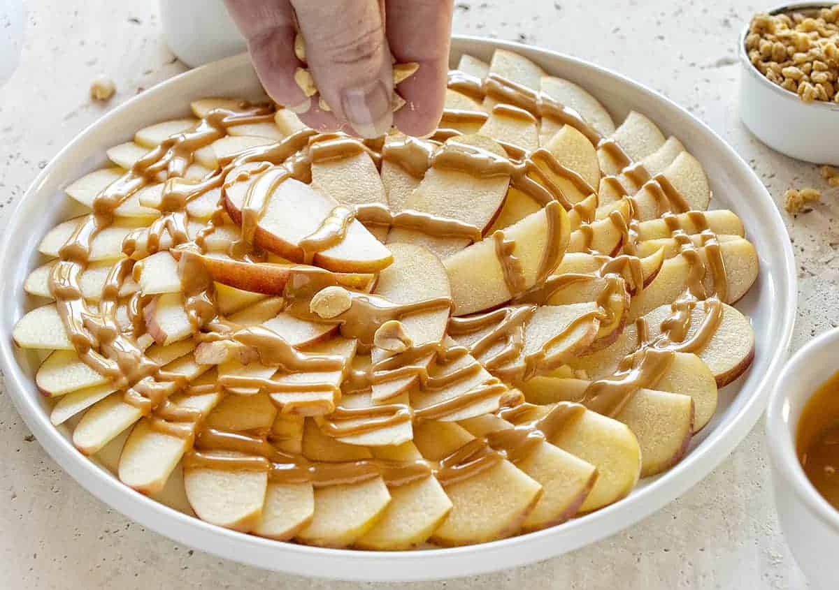 Apple Nachos with Peanut Butter are the perfect after-school snack! Easy to do, a few simple ingredients, and LOADS of happy faces! #applenachos #dessertnachos #afterschoolsnack #easyrecipes #kidrecipes #iambaker 苹果和花生酱和花生