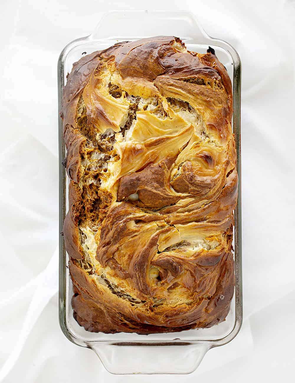 With cream cheese swirls and a super moist crumb, Pumpkin Cream Cheese Swirl Loaf will be craved long after pumpkin spice season is over. pumpkin cream cheese swirl loaf, pumpkin spice, homemade pumpkin spice, pumpkin bread, cream cheese swirls, iambaker, baking, bread recipes 头顶视图烤南瓜奶油奶酪漩涡面包