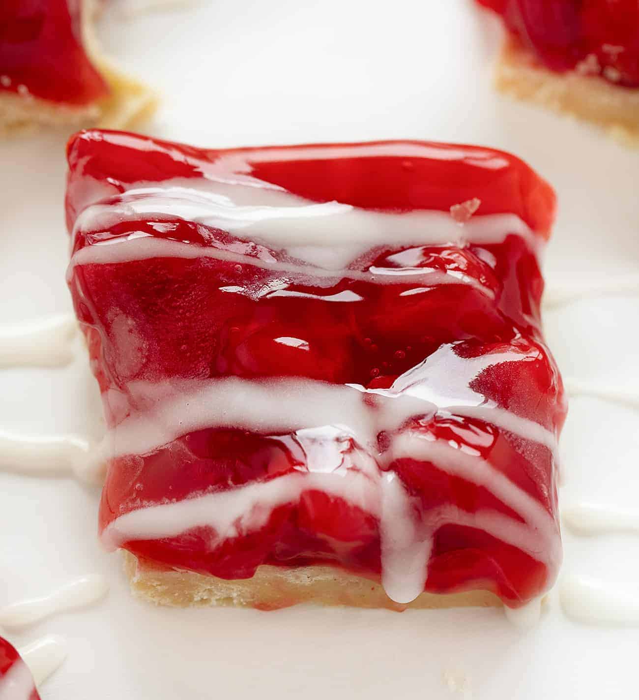 With just four ingredients, these Cherry Bars are as easy as they are delicious. cherry bars, easy desserts, desserts, iambaker, cherry pie filling, butter crumb, homemade icing, potluck recipes, bars 樱桃棒配自制糖衣