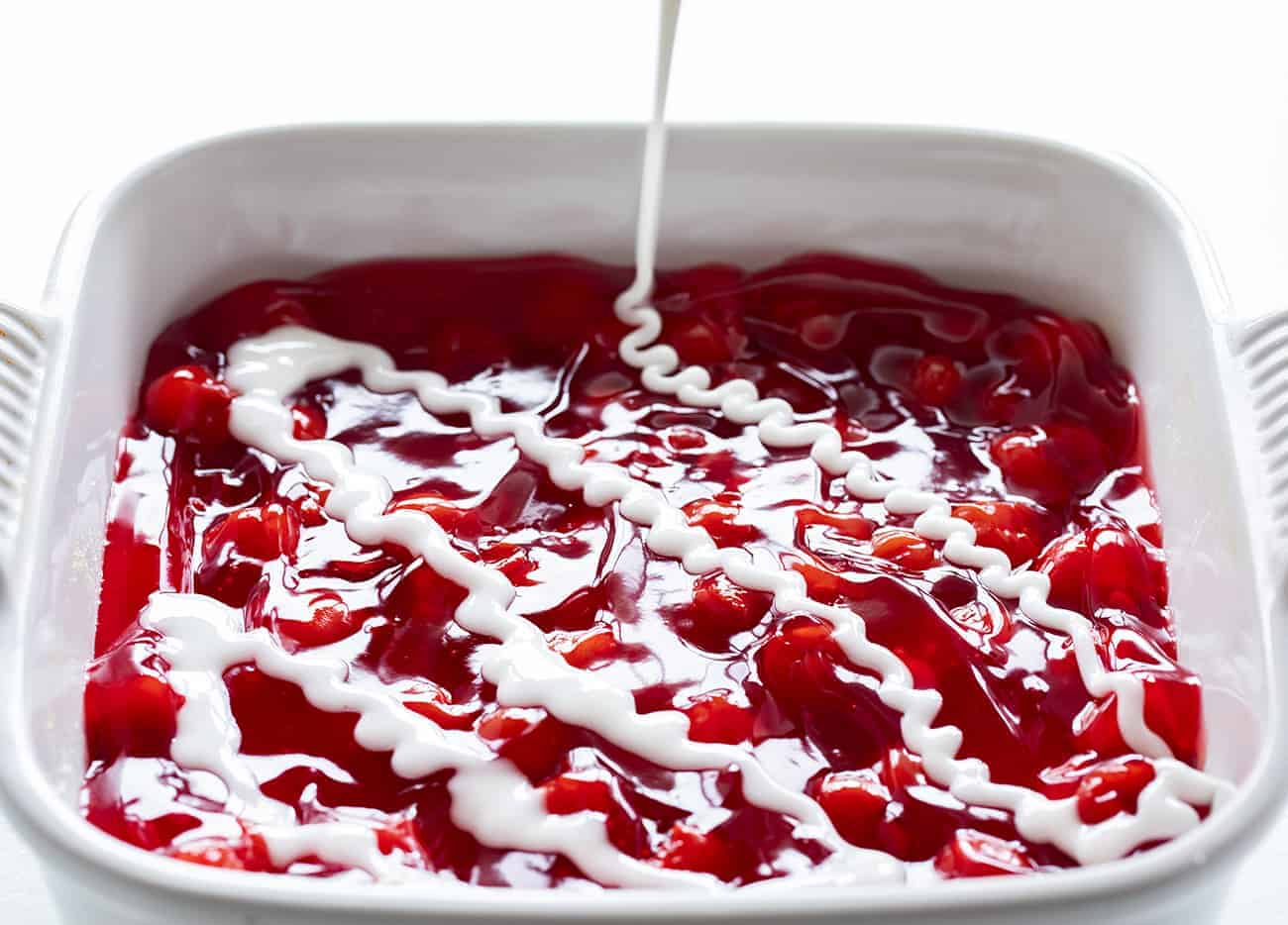 With just four ingredients, these Cherry Bars are as easy as they are delicious. cherry bars, easy desserts, desserts, iambaker, cherry pie filling, butter crumb, homemade icing, potluck recipes, bars 在樱桃棒上淋上糖霜