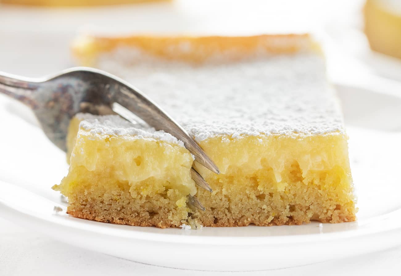 Lemon Ooey Gooey Cake is a Fantastic and EASY semi-homemade Dessert! Ooey Gooey Cake, Lemon Cake, Easy Lemon Cake, Easy Lemon Ooey Gooey Cake, How to Make Ooey Gooey Cake, Dessert, Cake, Recipes, i am baker, cake mix cake, lemon cake recipe 叉子切柠檬软糖蛋糕