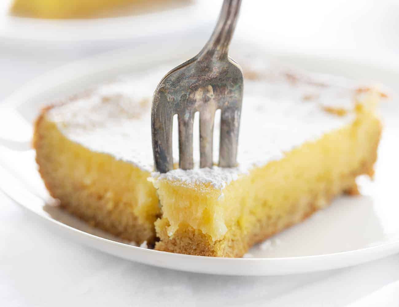 Lemon Ooey Gooey Cake is a Fantastic and EASY semi-homemade Dessert! Ooey Gooey Cake, Lemon Cake, Easy Lemon Cake, Easy Lemon Ooey Gooey Cake, How to Make Ooey Gooey Cake, Dessert, Cake, Recipes, i am baker, cake mix cake, lemon cake recipe 叉子拿一块柠檬软软的蛋糕