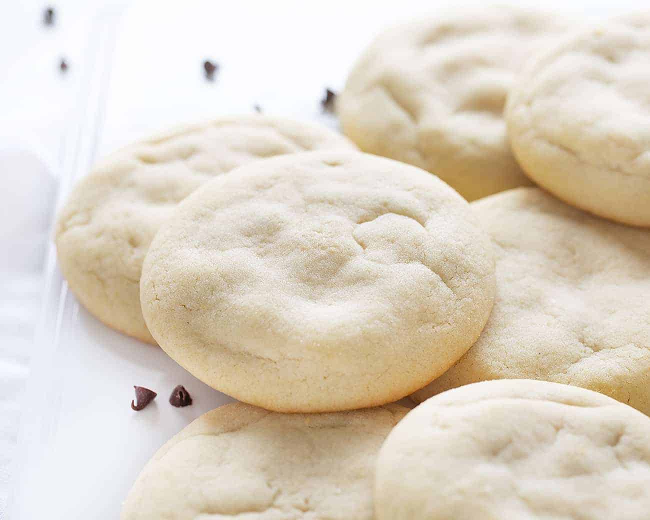 Chocolate Chip Cheesecake Sugar Cookies start with the perfect sugar cookie recipe that surrounds a creamy, chocolatey center! Sugar Cookies, Sugar Cookie Recipe, How to Make Amish Sugar Cookies, Easy Sugar Cookie Recipe, Stuffed Cookies, How to Make Stuffed Cookies, Chocolate Chip Cheesecake Stuffed Cookies, Stuffed Cookie Recipe, Dessert, Cookies, Recipes, i am baker 糖饼干和巧克力芝士蛋糕填堆放在白色的板