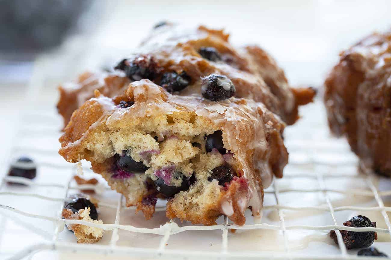 Fresh Blueberry Fritters that are made with a cakey batter incorporated with fresh blueberries are the ultimate homemade treat! Homemade Fritters, Fritters Recipe, Blueberry Fritters, Fresh Blueberry Fritters, Breakfast, How to Make Fritters, Donuts, Recipes, Fried Fritters, i am baker, iambaker 蓝莓馅饼,咬了一大口露出里面