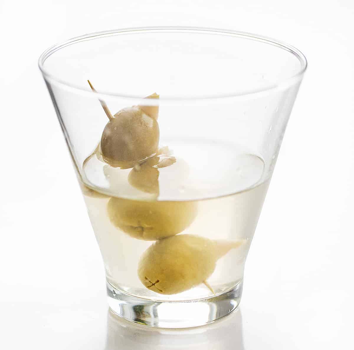 Make your own Dirty Martini with your favorite vodka and stuffed olives. dirty martini, martini recipe, homemade dirty martini, cocktail recipes, iambaker, i am baker 与3橄榄牙签一杯伏特加马提尼——肮脏的马提尼