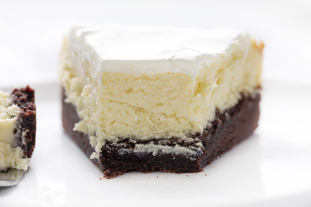视图切成布朗尼底部奶酪蛋糕显示内部和叉子旁边