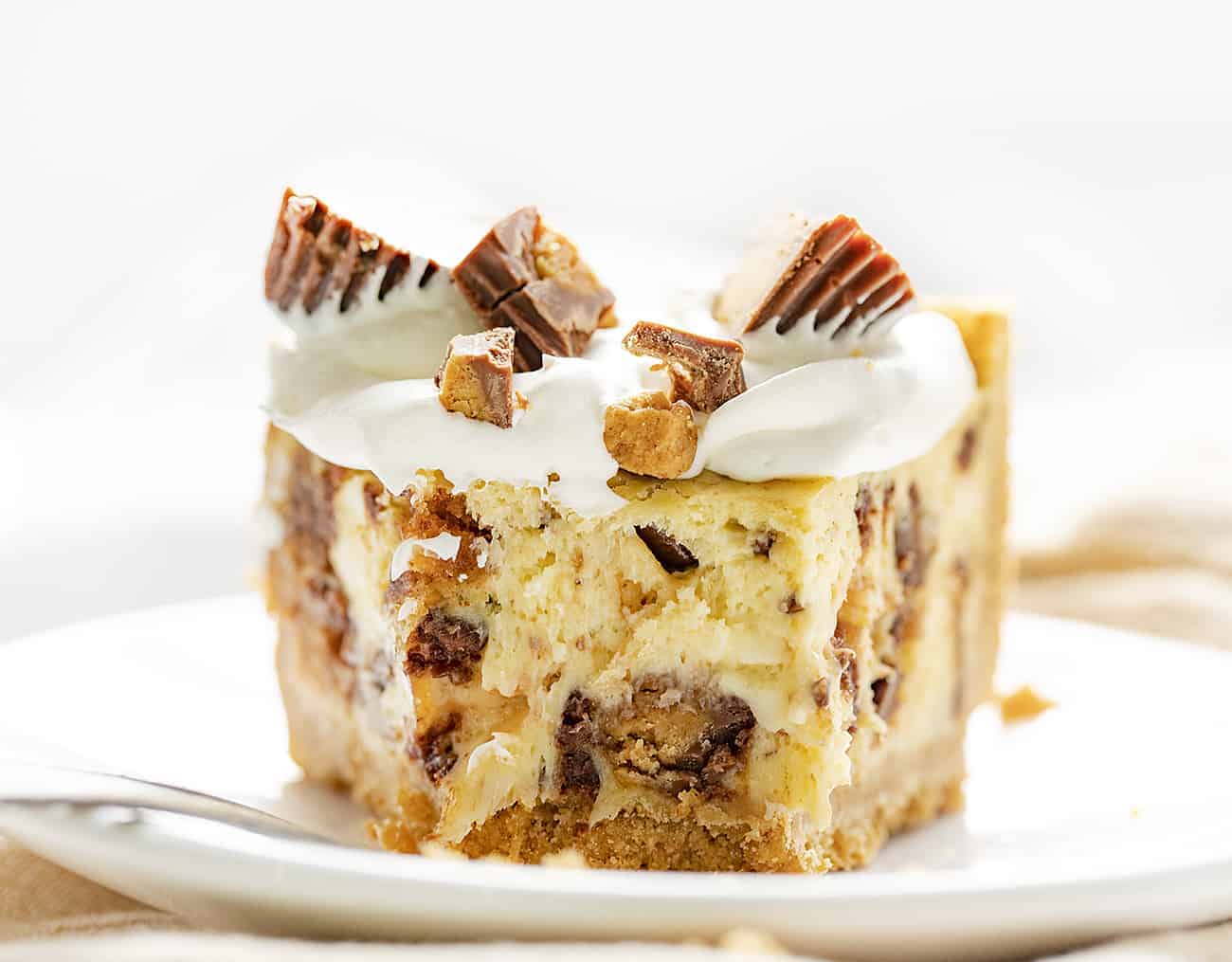 Reese's Cheesecake Pie takes one of my favorite candy treats, Reese's Peanut Butter Cups, and one of my favorite cakes, a cheesecake, and combines the two for this decadent dessert. Cheesecake, Reese's Cheesecake, How to Make Reese's Cheesecake, How to Make Candy Cheesecake, Easy Cheesecake, Summer Baking, Baking, Recipes, Desserts, Easy Desserts, Reese's Peanut Butter Cups, iambaker, i am baker 切瑞茜的芝士蛋糕配方与块失踪,叉放在盘子里