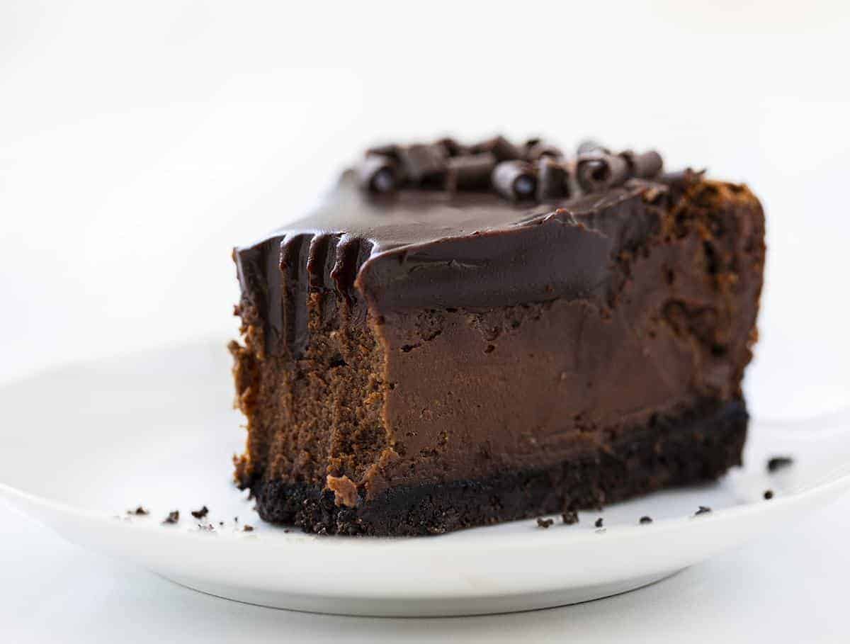 一块巧克力芝士蛋糕，顶端去掉咬痕，放在白盘子里