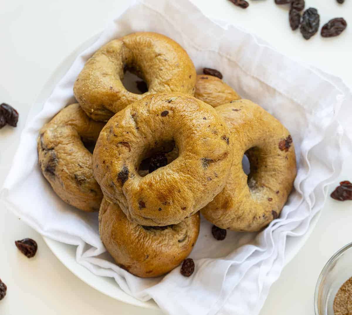 Cinnamon Raisin Bagels are homemade bagels that are loaded with plump raisins and just the right amount of cinnamon spice! Cinnamon Raisin Bagels, How to Make Cinnamon Raisin Bagels, Easy Cinnamon Raising Bagels, the best bagels, homemade bagels, the Best Homemade Bagels, Sweet Bagels, Bagel Recipe, Breakfast, Recipes, i am baker, iambaker 开销的形象肉桂葡萄干百吉饼在白色碗葡萄干