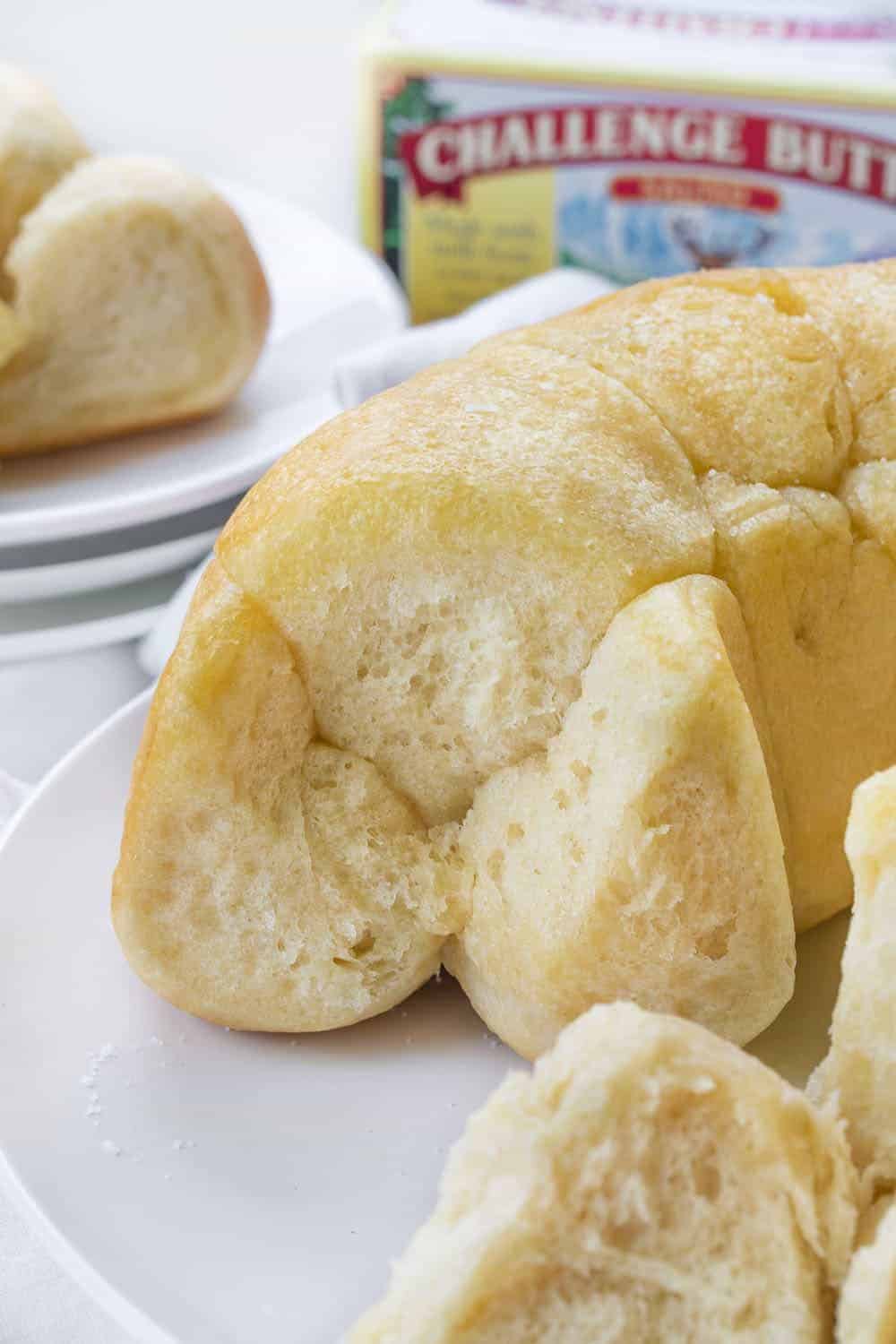 Buttery Bubble Bread is homemade bread that is a soft, salty, and buttery pull-apart bread that is easy to make and perfect for dinner rolls! Butter Bread, Bubble Bread, Buttery Bubble Bread, Bundt Bread, Dinner Rolls, Thanksgiving, Christmas rolls, bread recipe, homemade bread, rolls, i am baker, iambaker, recipes 泡泡面包的配方与碎片显示内部和碎片在盘子后面