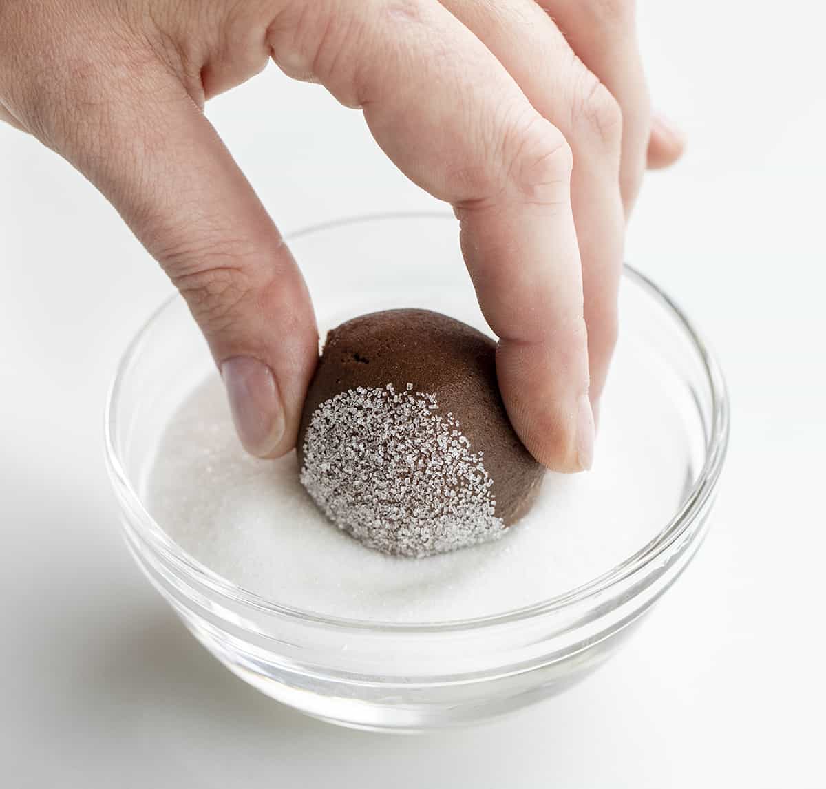 将巧克力曲奇面团浸入砂糖中。