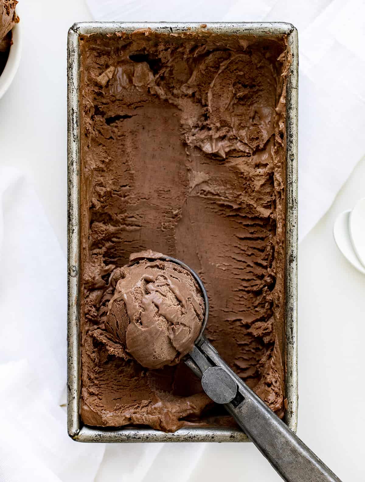 锅的冷冻No-Churn巧克力冰淇淋柜台上一个白色的冰淇淋勺满开销。