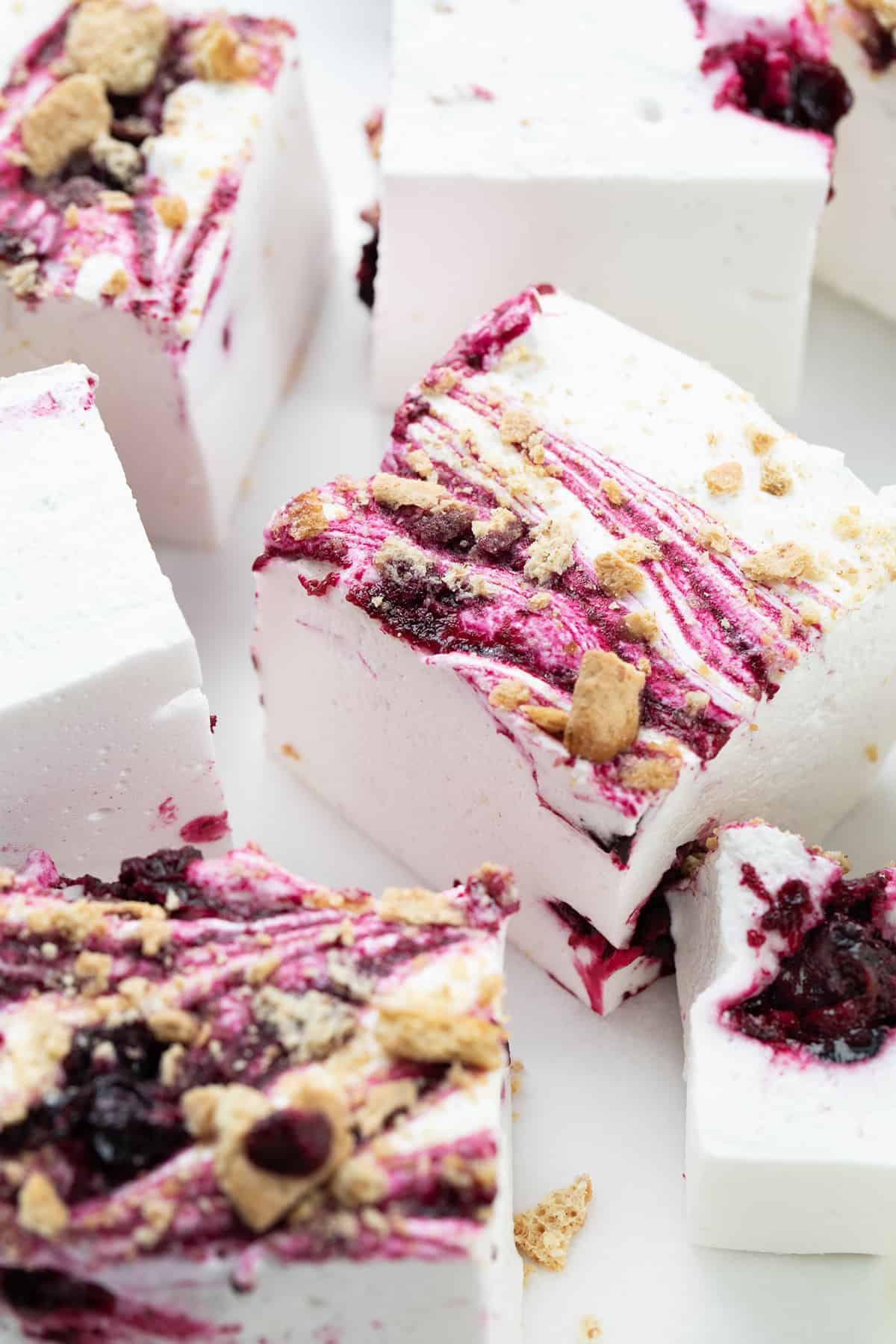 把美味的蓝莓棉花糖放在白色的表面上，切成正方形。