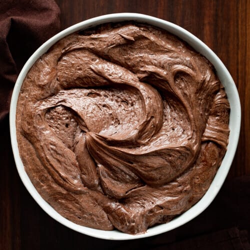 碗貂巧克力糖霜在黑暗的砧板。