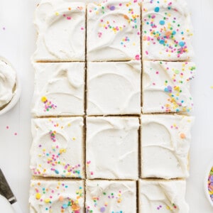 整个Vanilla-Delight蛋糕或白色蛋糕与柔和的白色柜台洒,切成块。