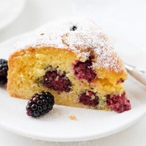 黑莓的早餐蛋糕在白色与叉板。