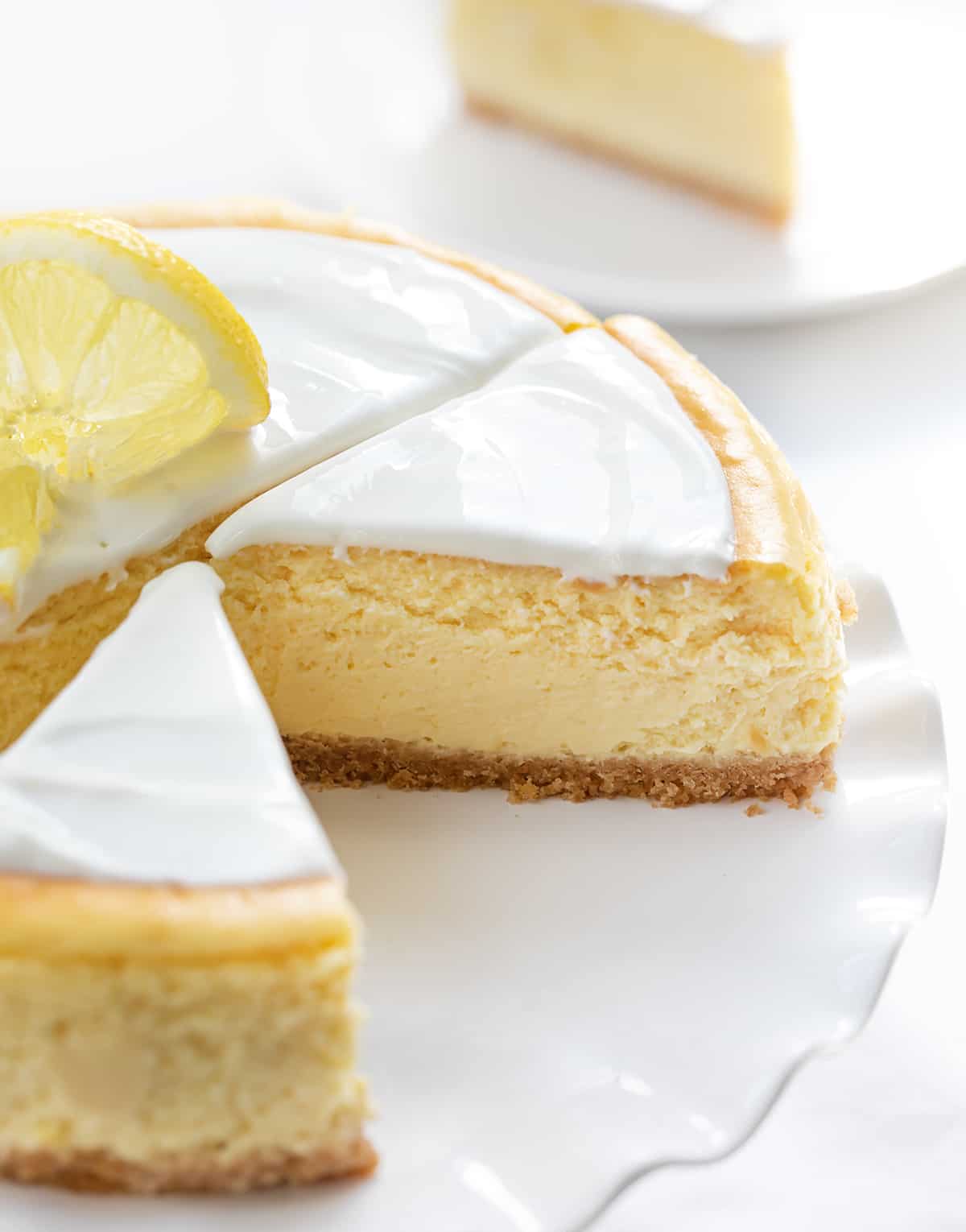 柠檬芝士蛋糕一个白色蛋糕站在褶边,用一块板在后台。