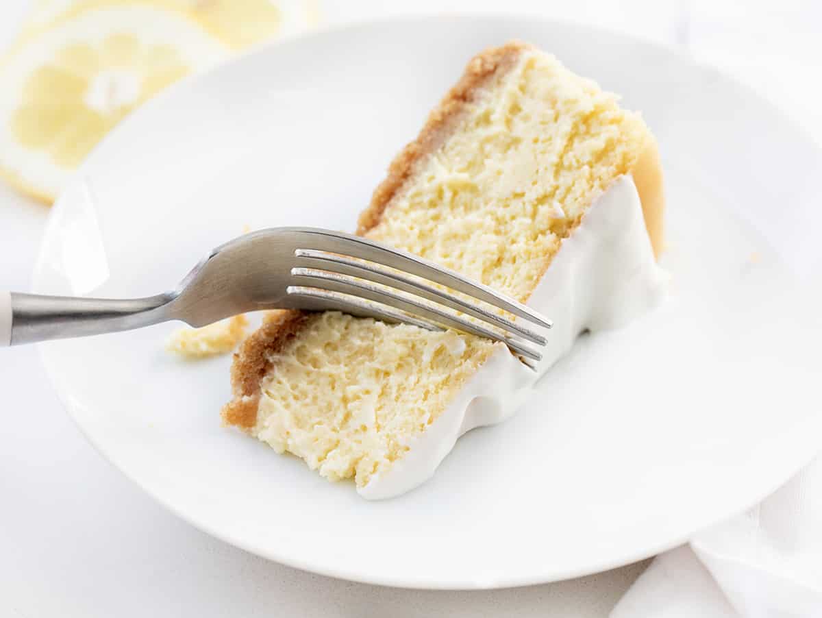 白色板片柠檬芝士蛋糕用叉子把一口。