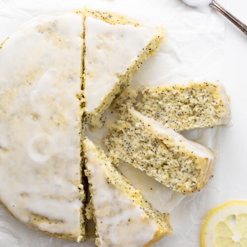 整个柠檬罂粟籽蛋糕一块白色的羊皮纸上四块,两块显示温柔的碎屑。