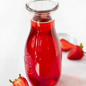 一瓶草莓简单糖浆草莓包围。