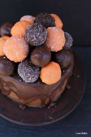 With a perfect chocolate cake smothered in milk chocolate ganache and topped with donuts, you will definitely choose this treat over a trick! #halloweencake #halloweencakewithanawesomesurprisetreat #iambaker #chocolatecake #donutholes #ganache #milkchocolateganache #halloweentreat #dessert #baking 万圣节蛋糕的头顶{有一个很棒的惊喜!}