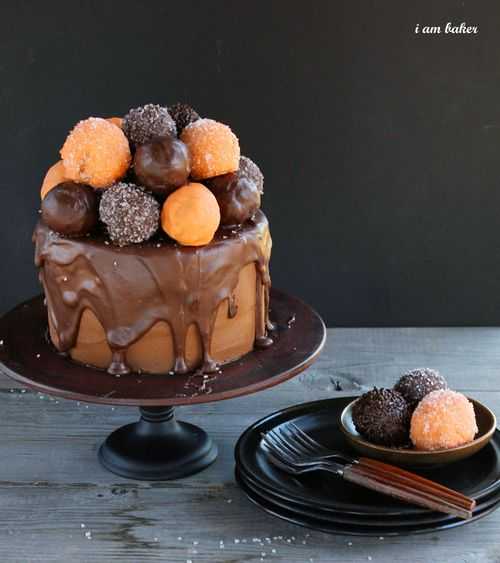 With a perfect chocolate cake smothered in milk chocolate ganache and topped with donuts, you will definitely choose this treat over a trick! #halloweencake #halloweencakewithanawesomesurprisetreat #iambaker #chocolatecake #donutholes #ganache #milkchocolateganache #halloweentreat #dessert #baking 万圣节蛋糕{有一个很棒的惊喜!}