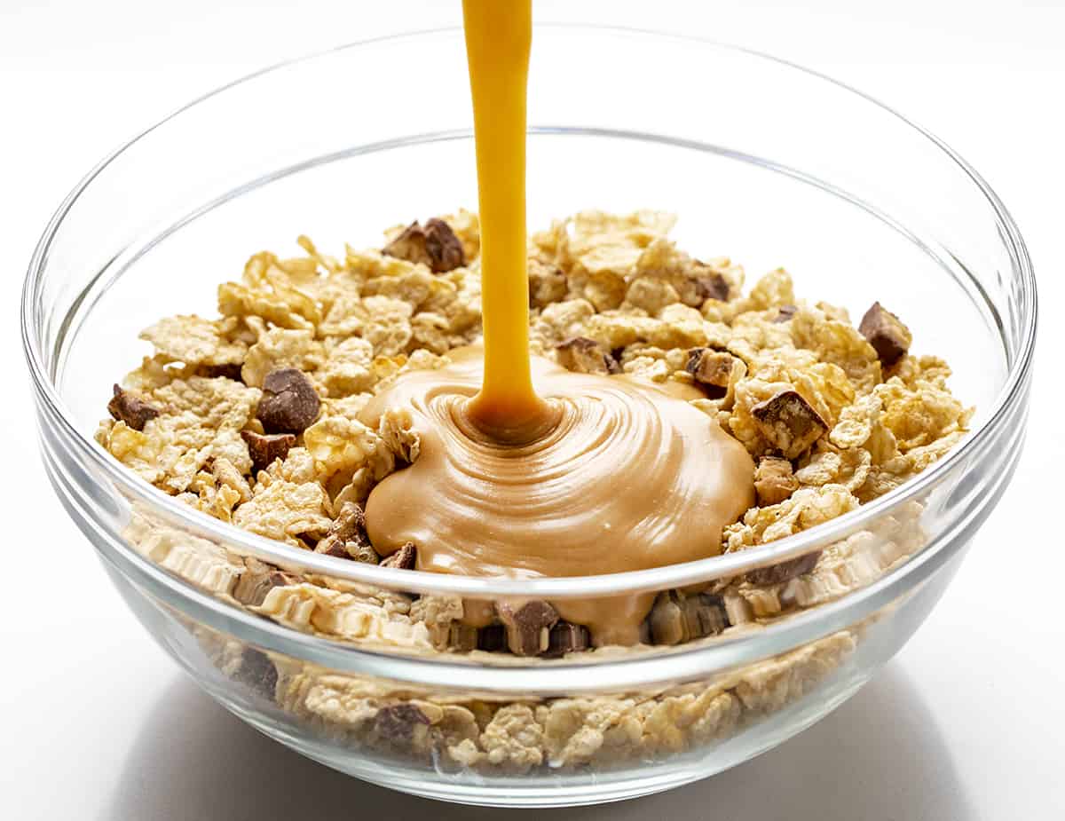 把酱汁倒在特制K和士力架上，制作特制K巧克力棒。甜点，Scootchero酒吧，SpecialK酒吧，酒吧，酒吧食谱，scootch-er-oo酒吧，snicekrs酒吧，儿童零食，巧克力，花生酱，奶油糖果，食谱，我是面包师，iambaker。