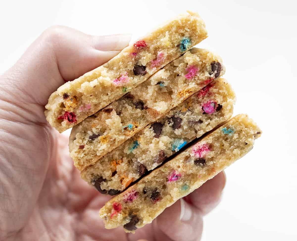 手拿着饼干碎一半显示内部结构。烘焙,饼干,饼干食谱,甜点,彩虹芯片,彩虹饼干,彩虹芯片巧克力饼干,软饼干,耐嚼饼干,饼干面团,我是贝克,iambaker