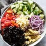 所有的原料为希腊通心粉沙拉在大型白色碗灰色餐巾