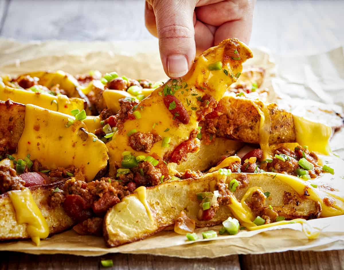 拿起一个薯条从辣椒芝士薯条