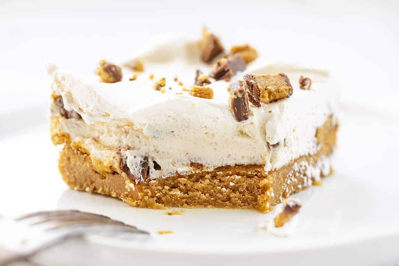 A Reeses Peanut Butter Bar with a Section Removed and Fork Resting on White Plate