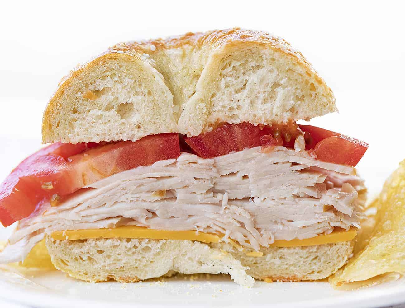 近距离内的盐百吉饼三明治层的土耳其,西红柿,奶酪旁边芯片