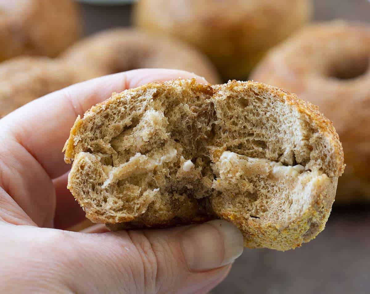 在肉桂糖百吉饼被手