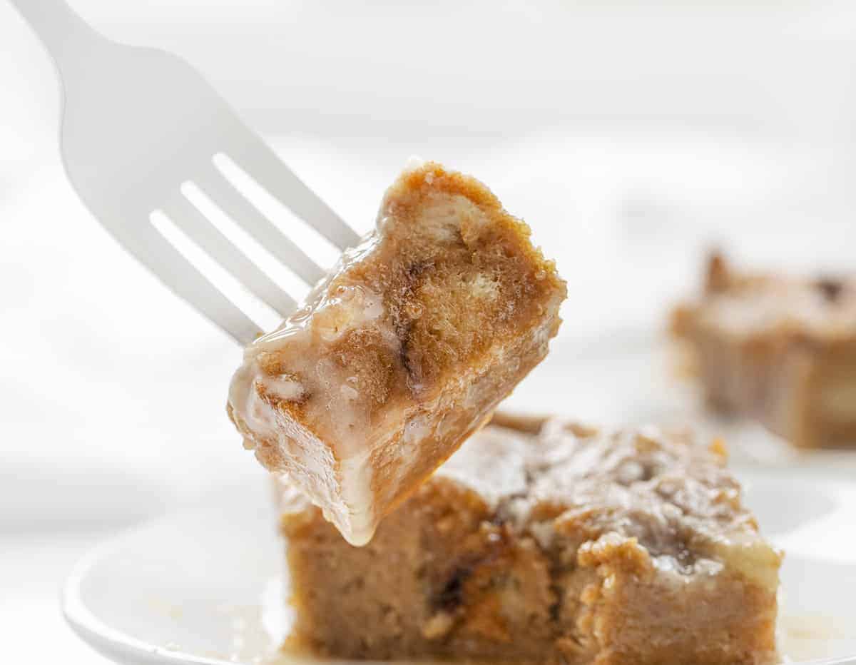 白色叉子拿着巧克力焦糖面包布丁食谱和盘子后面