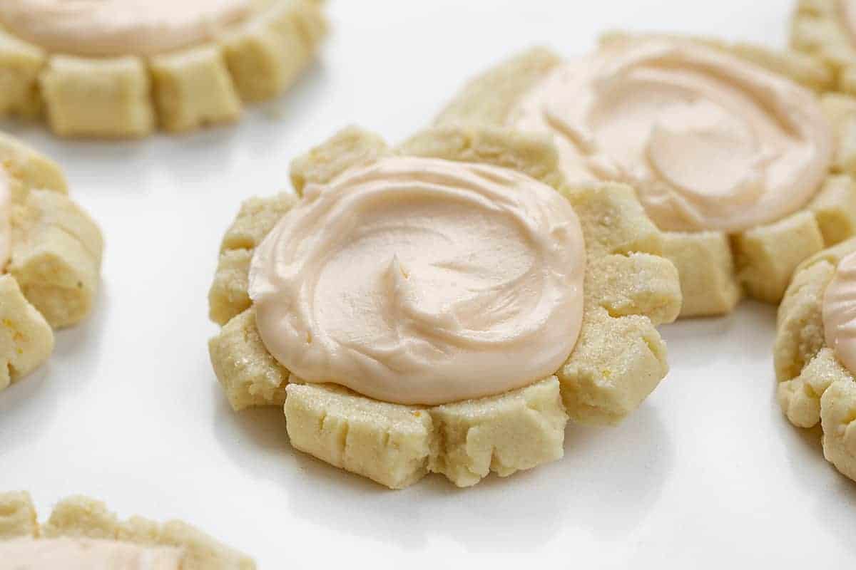 橘色与橙色结霜糖饼干——橙色痛饮饼干坐在白色的表面