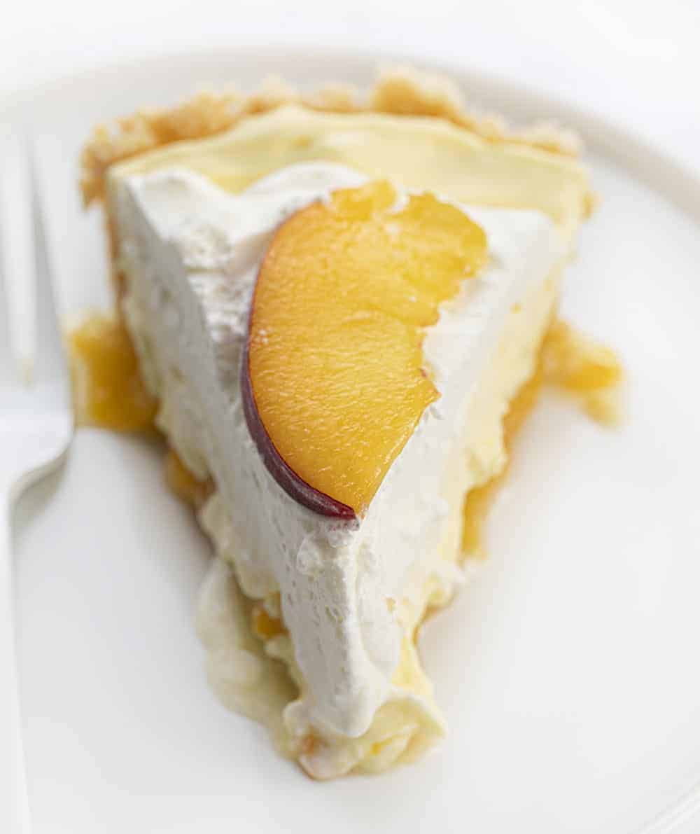 一块奶油桃子派，白盘子，白叉子