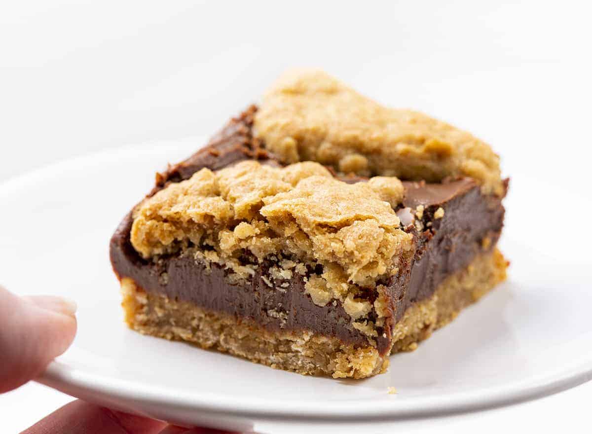 狂欢酒吧在一个白色的盘子上，手拿着盘子