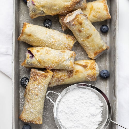 蓝莓芝士蛋糕蛋卷，上面撒上砂糖。甜点蛋卷，甜点，蛋卷，蛋卷食谱，蓝莓芝士蛋糕，芝士蛋糕，零食，甜点开胃菜，热甜点，蓝莓甜点，夏天甜点，如何做芝士蛋糕蛋卷，食谱，我是面包师，iambaker