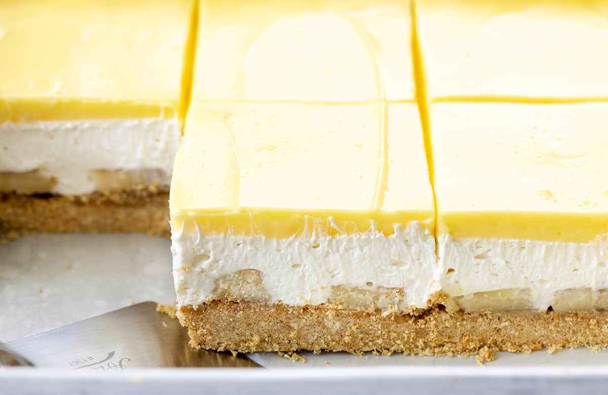 香蕉甜点切在平底锅与餐铲。甜点，不烤甜点，不烤，香蕉甜点，夏季甜点，分层甜点，夏季食谱，烧烤食谱，香蕉布丁，丰盛的甜点，丰盛的食谱，全麦饼干，我是面包师，iambaker。