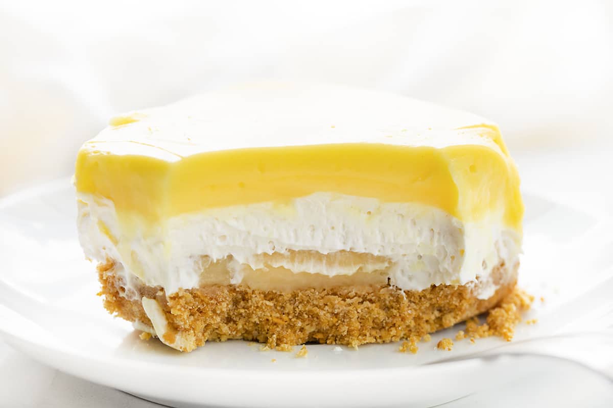 一块香蕉繁茂与咬去显示内部纹理。甜点，不烤甜点，不烤，香蕉甜点，夏季甜点，分层甜点，夏季食谱，烧烤食谱，香蕉布丁，丰盛的甜点，丰盛的食谱，全麦饼干，我是面包师，iambaker。