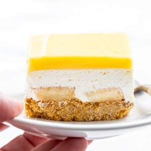 手拿着一盘香蕉郁郁葱葱的甜点。甜点,没有烤甜点,No-Bake、香蕉甜点,甜点,夏天分层的甜点,夏季食谱,烧烤食谱,香蕉布丁,郁郁葱葱的甜点,郁郁葱葱的食谱,全麦饼干,我是贝克,iambaker。