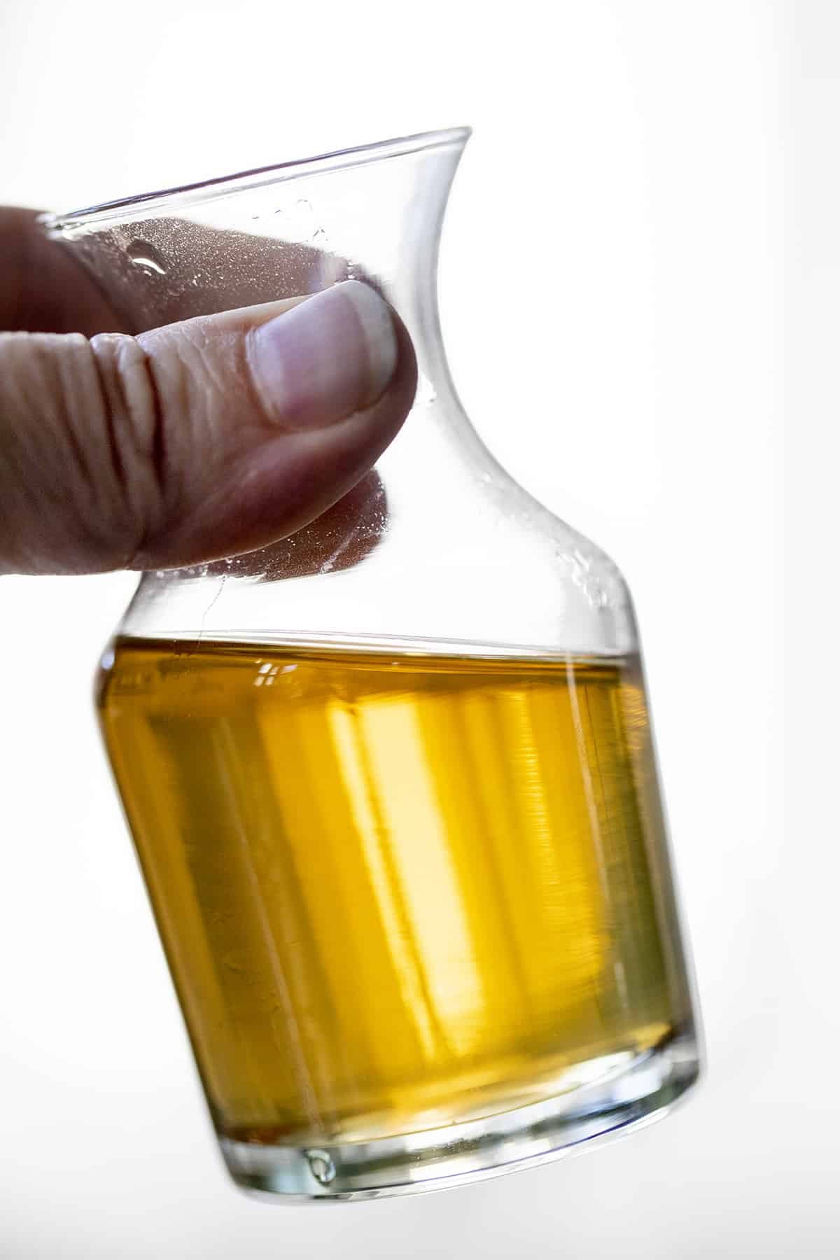 手拿一瓶香草糖浆。简单糖浆，如何制作简单糖浆，香草简单糖浆，如何使用简单糖浆，鸡尾酒糖浆，饮料，饮料，食谱，iambaker，我是面包师。