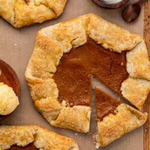 在砧板上自制的南瓜夹心饼没有切开，挨着鲜奶油和冰淇淋。甜点，感恩节，南瓜派加勒特，简单的南瓜甜点，如何做南瓜加勒特，节日甜点，简单的甜点，派皮，加勒特，我是面包师，iambaker